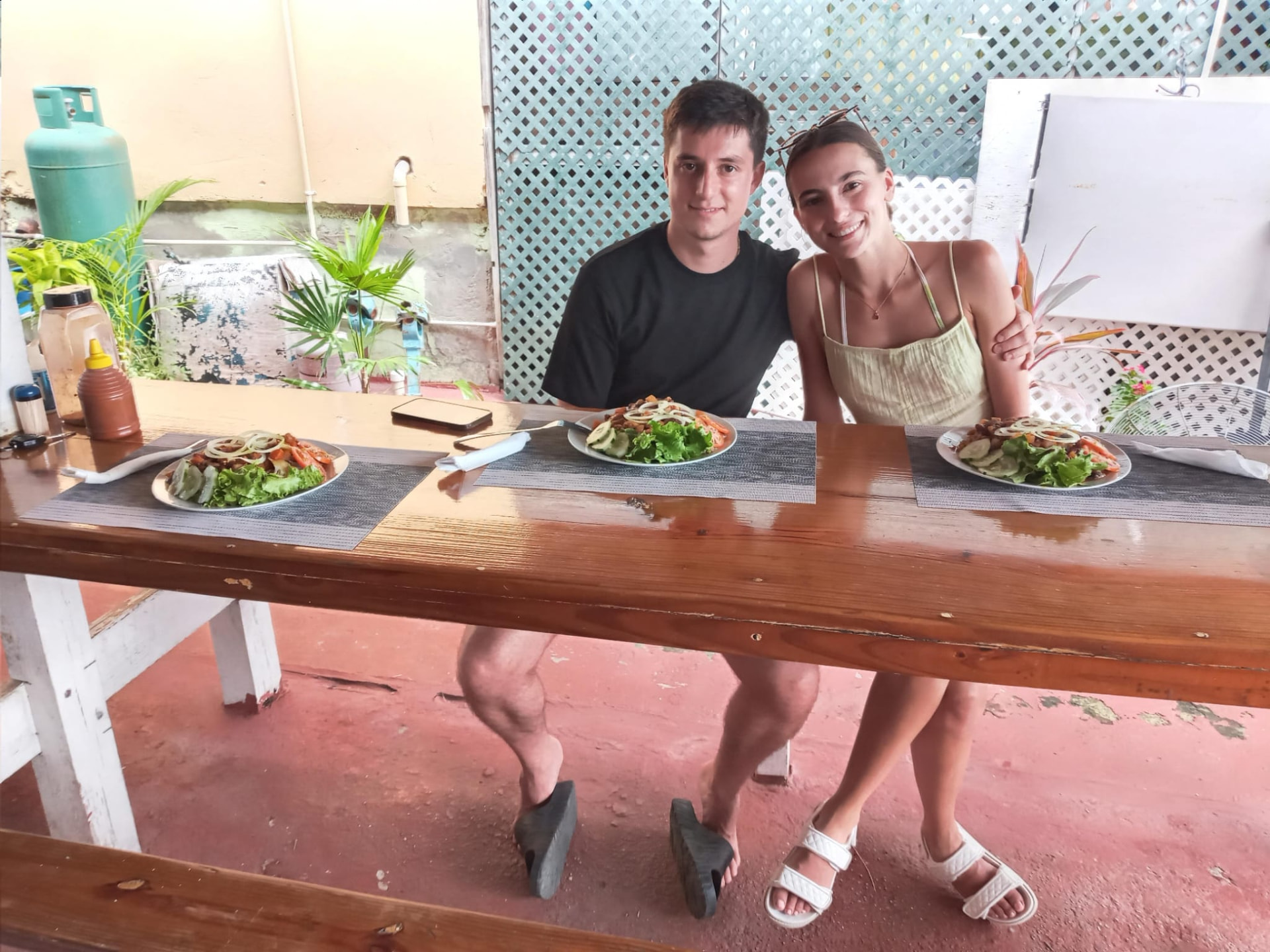 Couple enjoying a Bajan vegetarian lunch at a local Barbados eatery after a ride with On The House Taxi Service