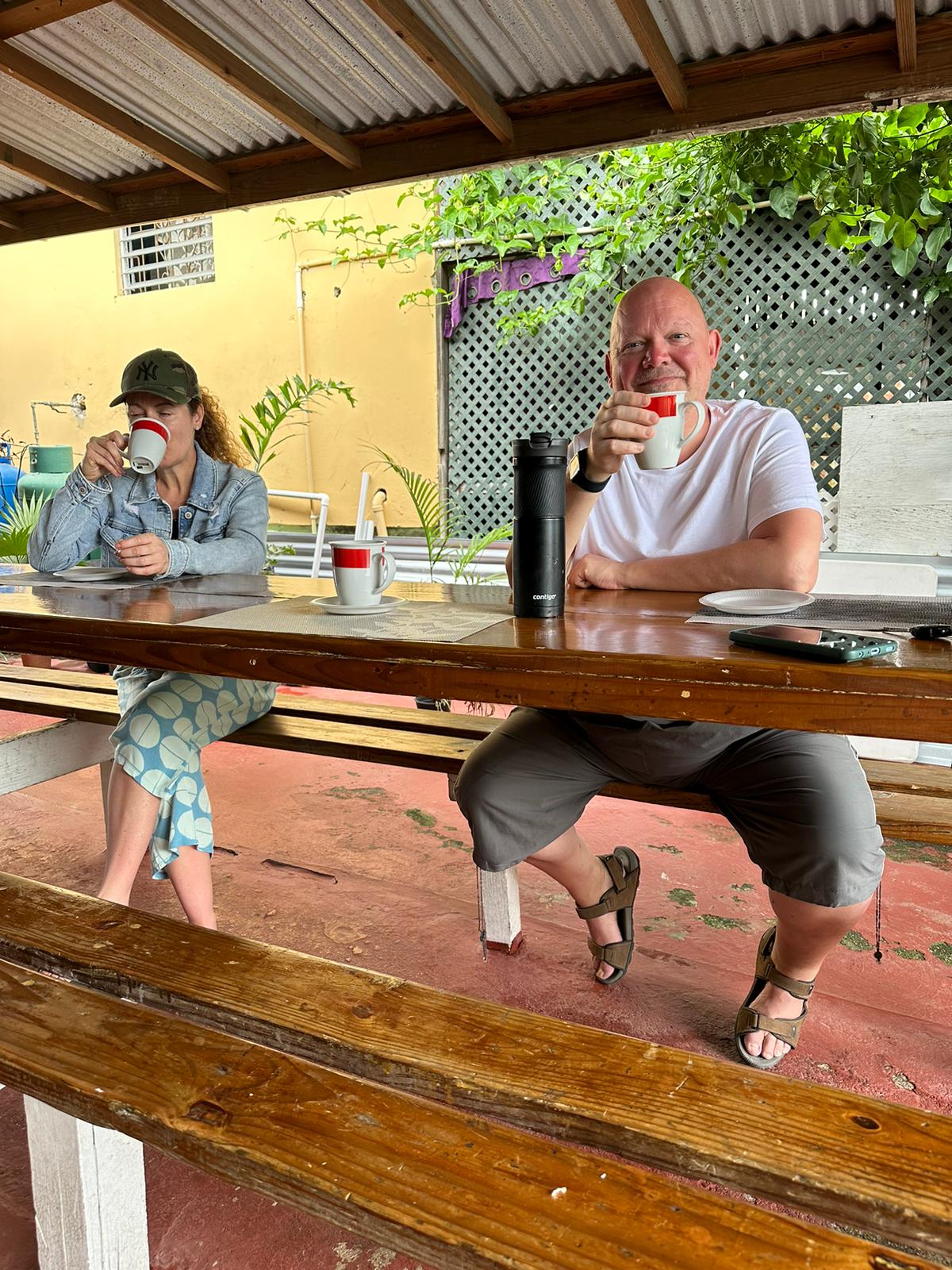 Happy guests enjoying coffee at a shaded lunch stop during a Barbados island tour with On The House Taxi Service