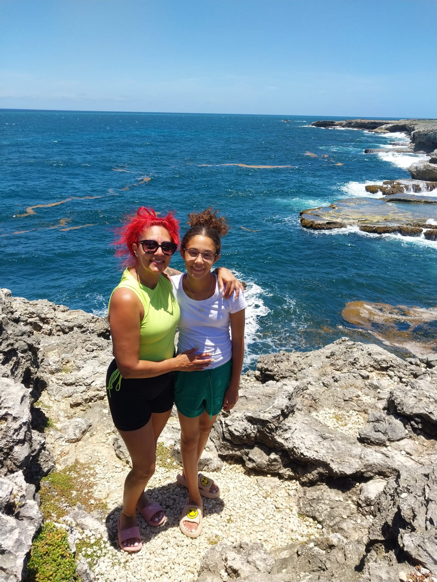 Two guests on the rocky St. Lucy cliffs looking out over the blue Barbados coastline