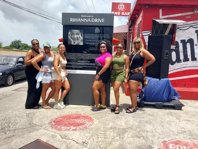 Group of happy visitors on a sightseeing island tour at Rihanna Drive, Bridgetown with On The House Taxi Service Barbados