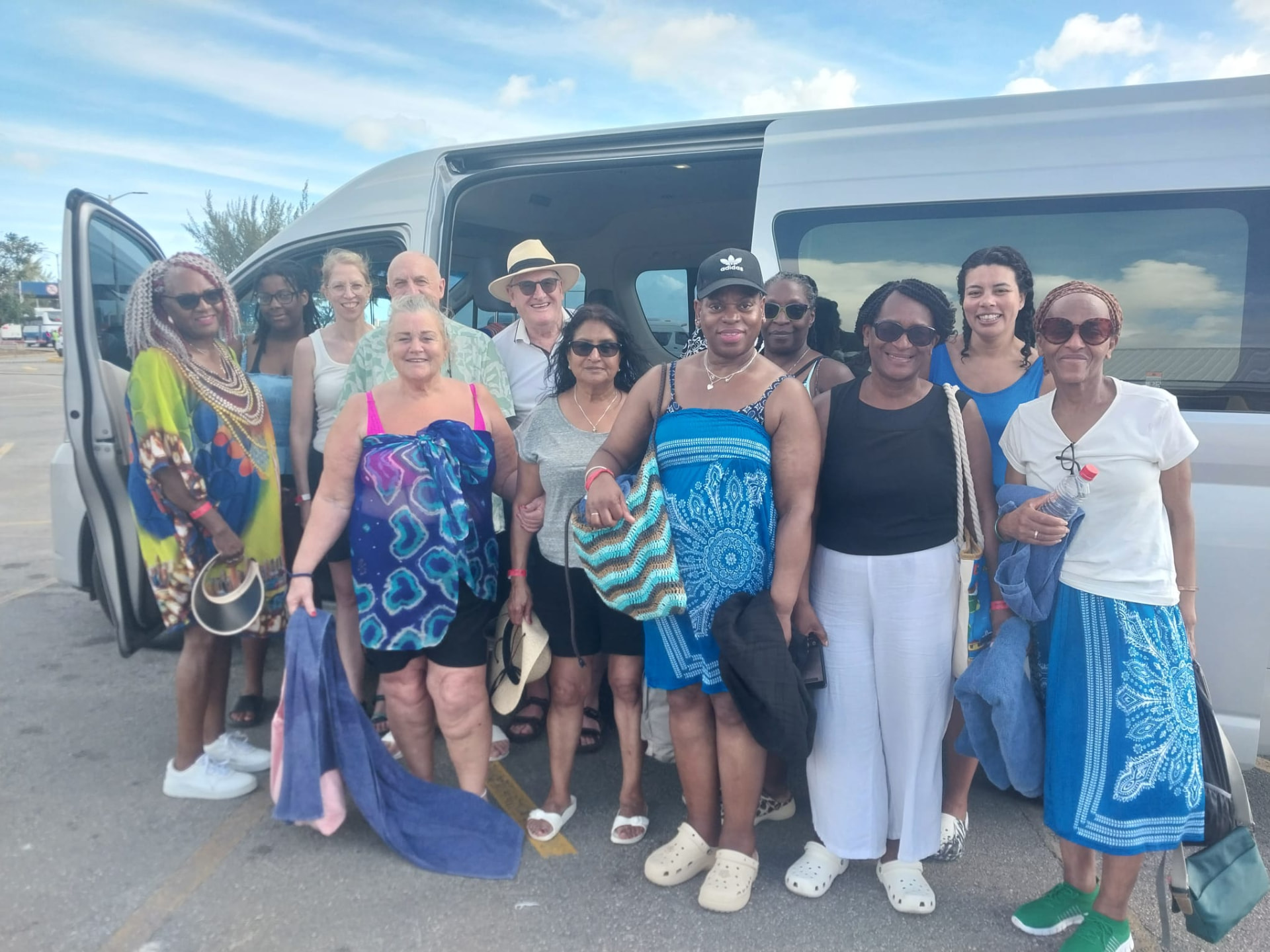Family group standing at the side door of the On The House Taxi Service van after a Barbados airport transfer