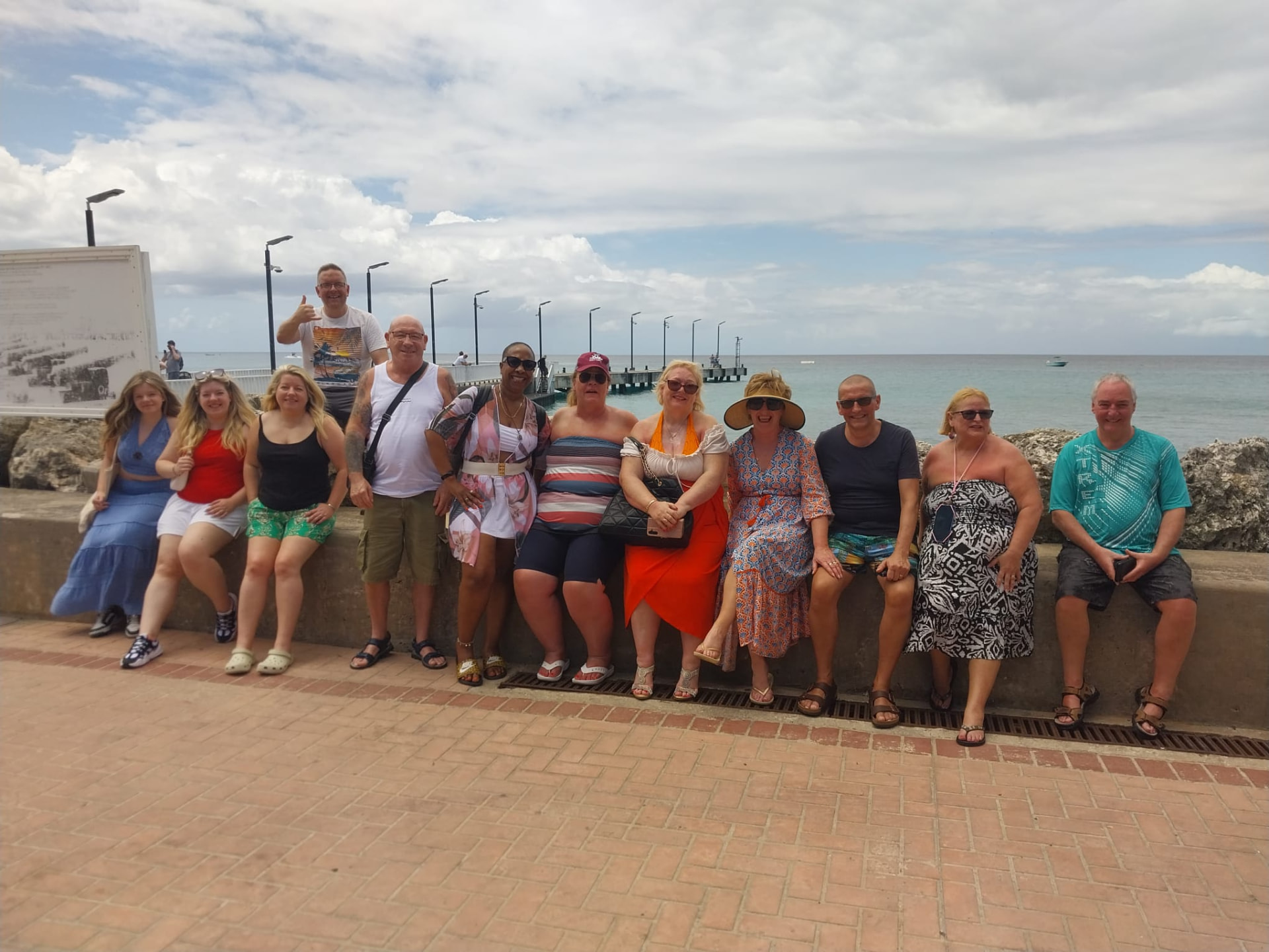 Tour group relaxing on the Speightstown sea wall in St. Peter, Barbados