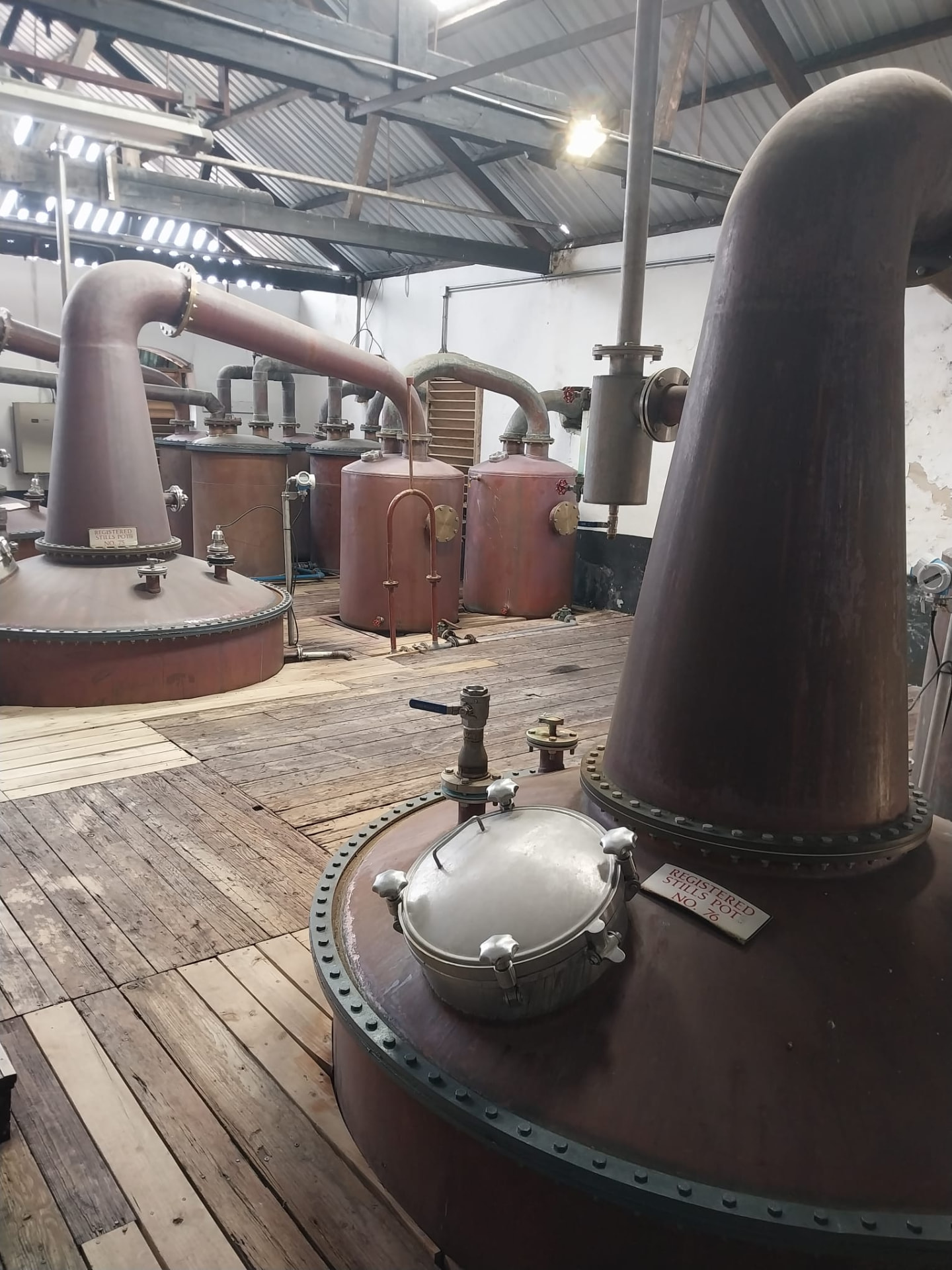 Copper pot stills inside the Mount Gay rum distillery in Barbados on a private rum tour transfer